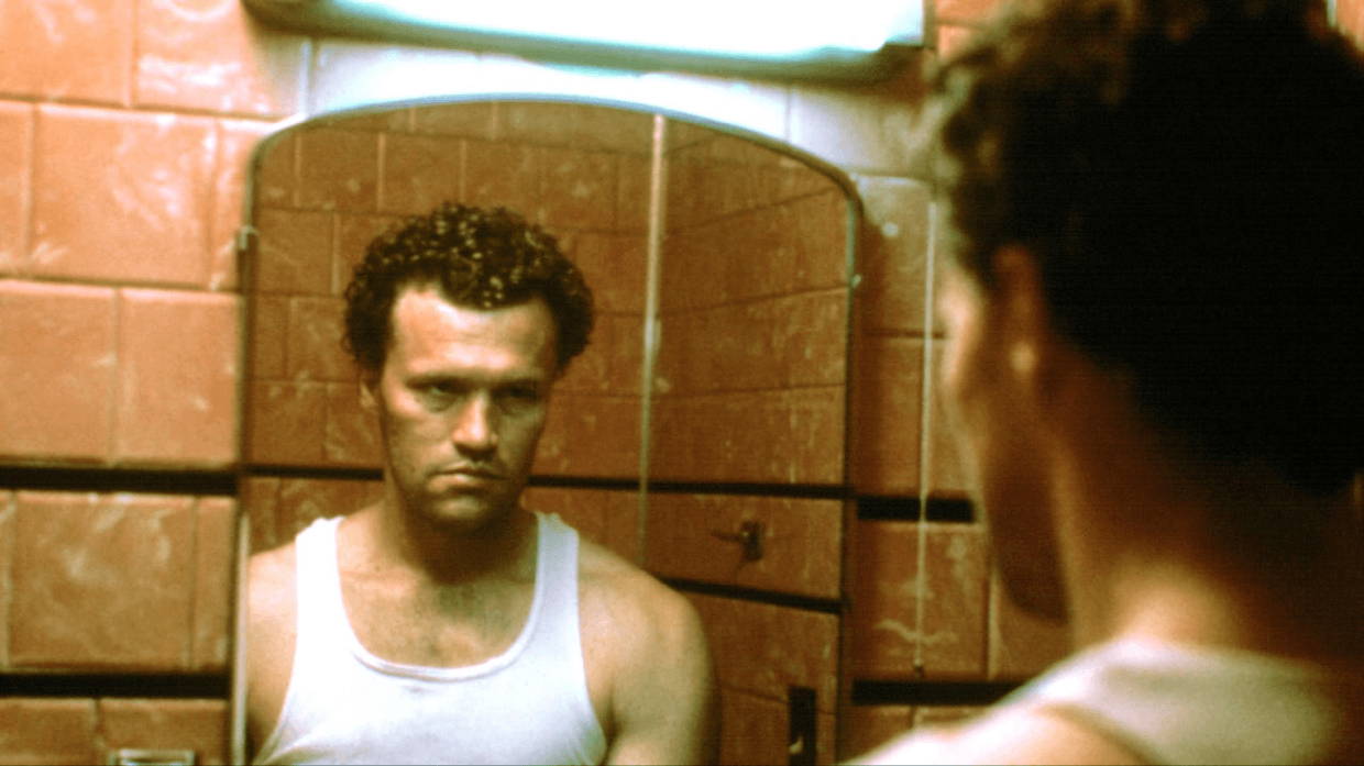 Henry Lee Lucas (Michael Rooker) trying to reckon with the devil in the mirror in Henry: Portrait of a Serial Killer (1990).